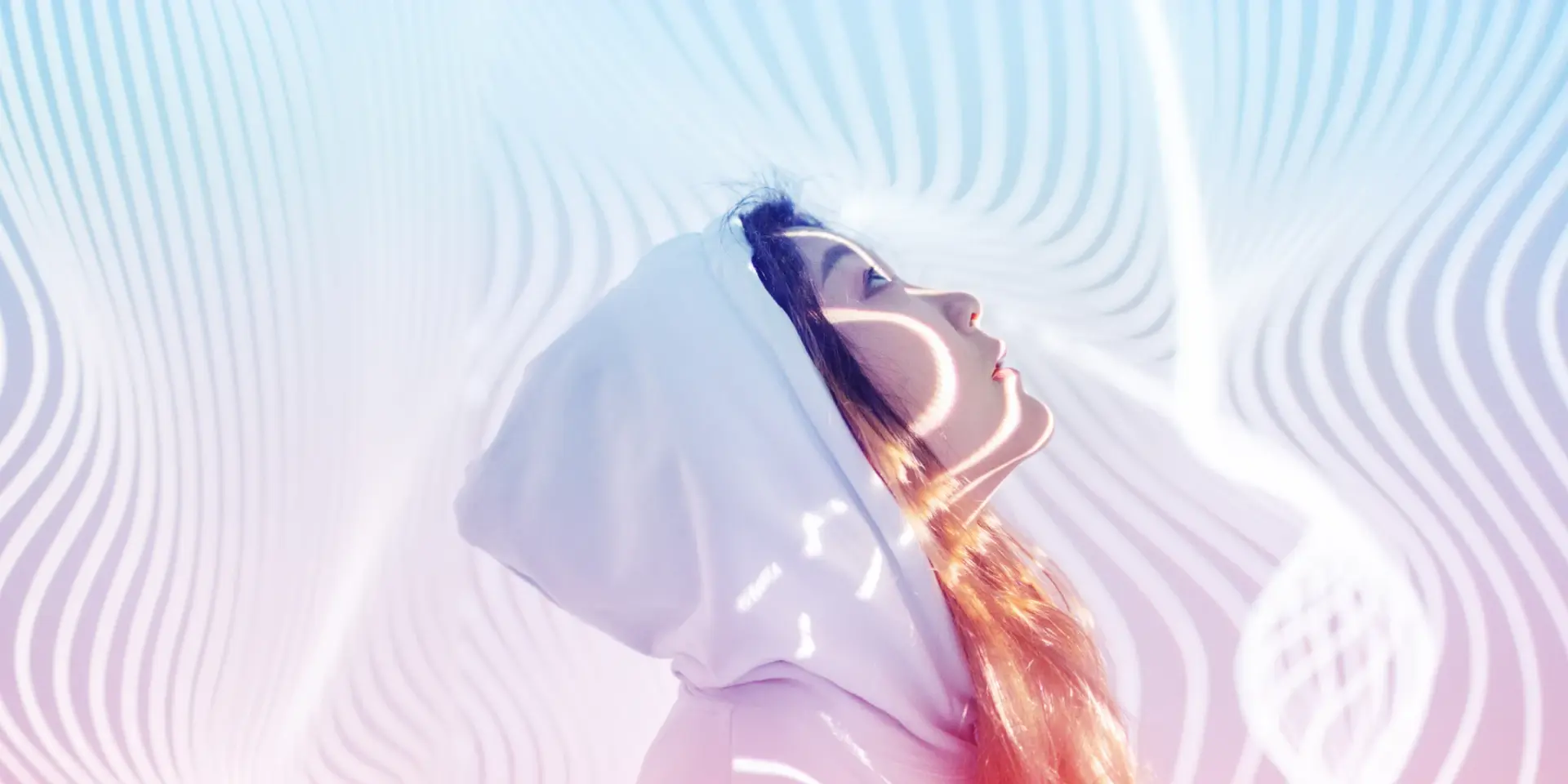 A person looking up towards the sky with geometric light rays around them.