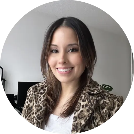 An image of Kim Alban, a woman with brown hair, wearing an animal print jacket over a white shirt.