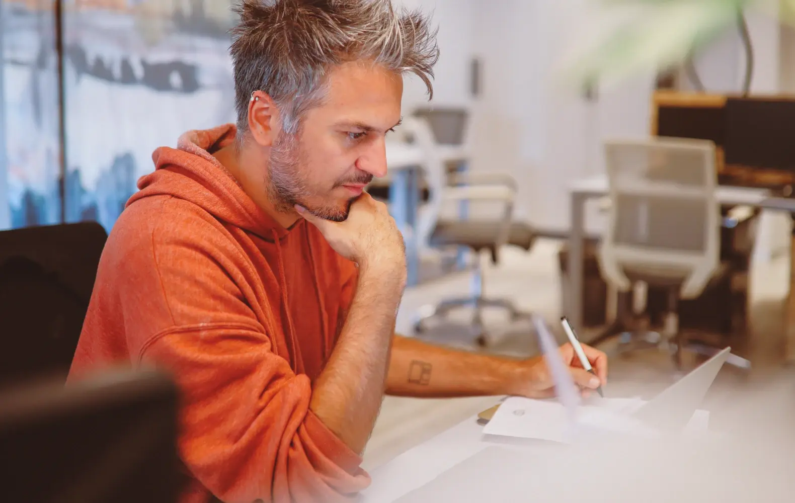 designer with orange hoody sketching in his office