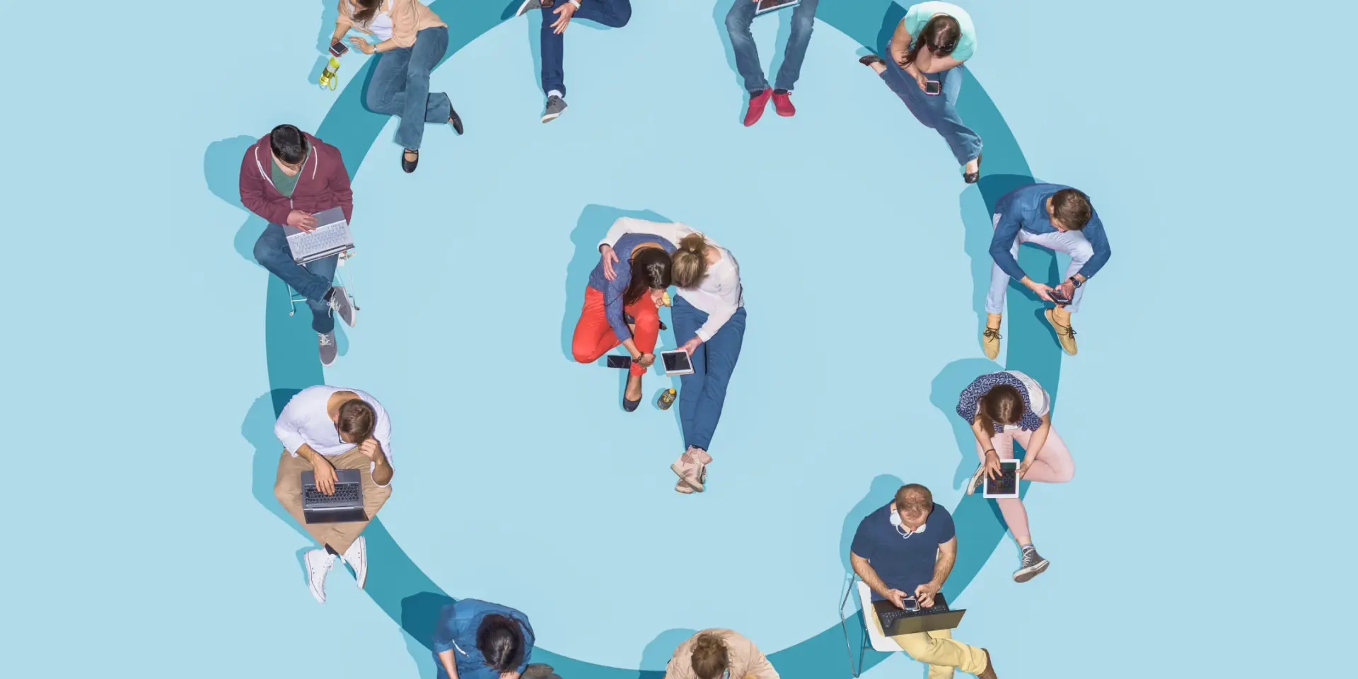 An image of people sitting in a circle with a duo sitting in the middle 